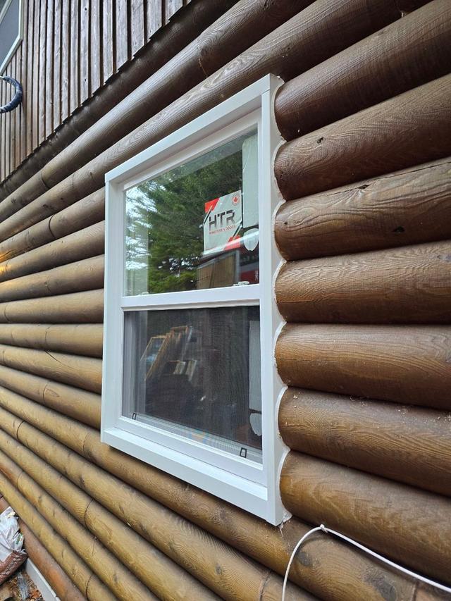 Newly installed windows in a log home wall
